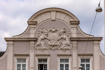 Elements of facade of house with bas-reliefs of lion figures, old coats of arms in Landshut, Bavaria, Germany.
