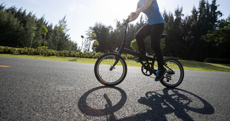 Fototapeta na wymiar Riding folding bike on sunny seaside road
