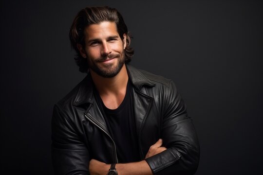 Portrait of a handsome man in leather jacket over black background.