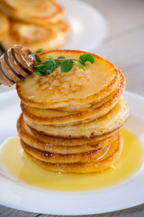 cooked sweet pancakes with honey in a plate