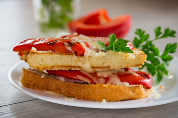 hot sandwich of fried toast bread with baked peppers and cheese