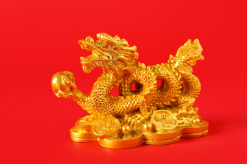 Golden dragon figurine on red background, closeup. Chinese New Year celebration
