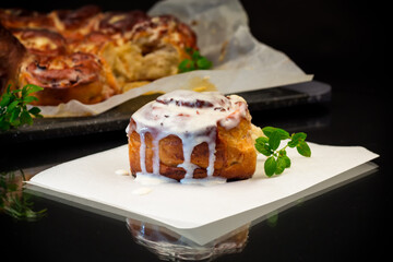 cooked baked sweet cinnabon with cream on black background