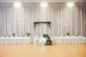 shot of the wedding hall decorated with flowers and lights, tables set with cutlery and beautiful decorations, wedding day