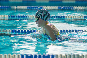 Swimmer child swims breaststroke swimming style in the pool - 681806351