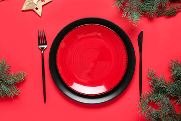 Beautiful table setting with Christmas tree branches on red background