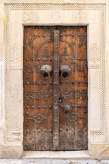 A decorated wooden door on a building in Tunisia.