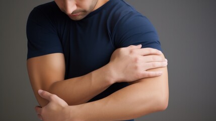A man grimacing in pain as he holds his arm, indicating discomfort or injury. - obrazy, fototapety, plakaty