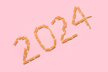 Figure 2024 made of raw pasta on pink background