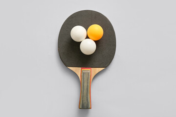 Ping-pong racket with balls on light background