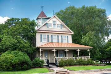 big classic american two level house with terrace and lawn in the front yard.