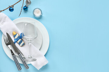 Festive table setting with Hanukkah decorations on blue background