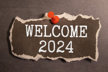 Welcome 2024 - New Year concept on a vintage slate blackboard isolated on white.