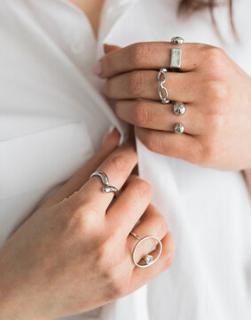 Women Jewelry concept. Woman's hands close up wearing rings and necklace modern accessories elegant lifestyle