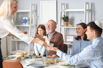 Happy little girl having dinner with her family at home on Hanukkah