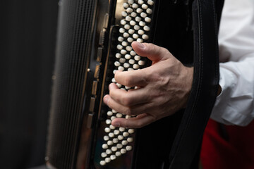 Accordion in the hands of a musician. Musical instrument.Musician playing the accordion, close-up.