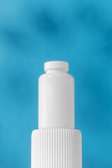  Mockup is a white jar with pills or vitamins on a podium. Medical preparations.