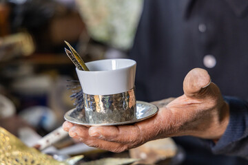 A hand crafted metal and ceramic cup at a metal work shop in the Tunis Souk.