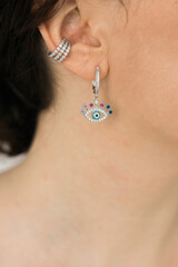 Detail of young woman wearing beautiful luxury earring. Handmade jewellery and accessories