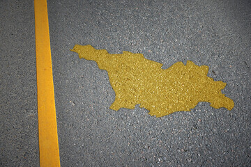 yellow map of georgia country on asphalt road near yellow line. - obrazy, fototapety, plakaty