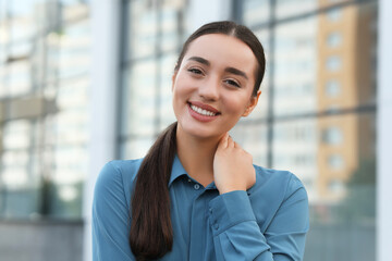 Portrait of beautiful woman outdoors. Attractive lady smiling and looking into camera