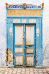 A blue and white door in a building in the city of Kairouan.