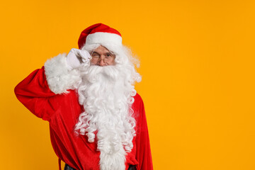Merry Christmas. Santa Claus winking on orange background, space for text