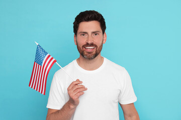 4th of July - Independence Day of USA. Happy man with American flag on light blue background