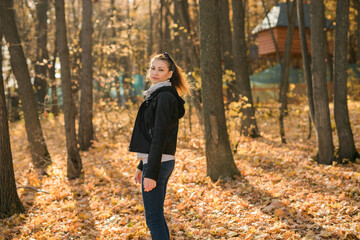 Outdoor atmospheric lifestyle portrait of young beautiful young woman copy space. Warm autumn fall season. Millennial generation and youth