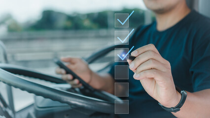 Male professional truck driver uses pen to mark correctly On the virtual screen, a survey on the car quality checklist from a smartphone application according to safety principles before driving. - obrazy, fototapety, plakaty