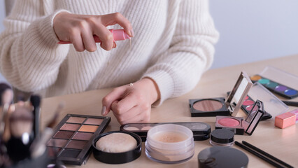 Close-up of makeup artist's hands among cosmetics. 