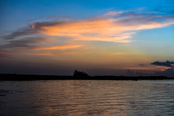 Fototapeta na wymiar orange clouds at sunrise over the lake
