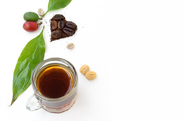 Amantes del café. Día Internacional. Corazón formado con granos tostados, cerezas y hojas del cafeto. Vista superior o cenital sobre superficie blanca y espacio para copiar.  