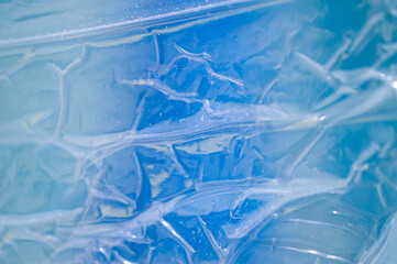 Blue plastic. Macro photography. It is transparent and wrinkled.