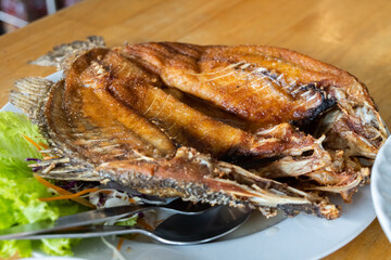 Fried sea bass. Served with green vegetables.