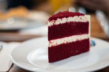 A red velvet cake is placed on a white ceramic plate.