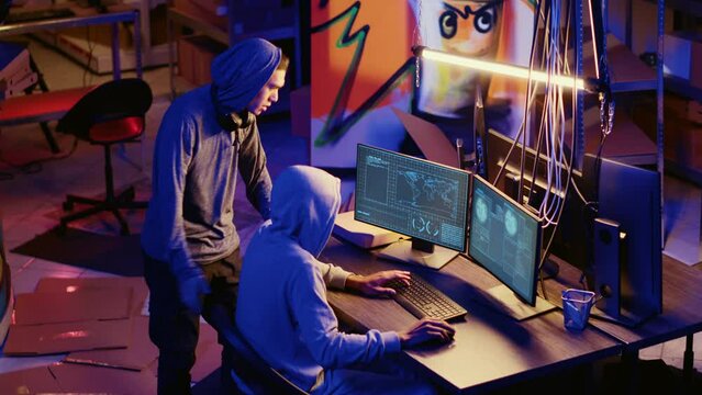 Hackers in underground bunker working together to take advantage of security breach after gaining unauthorized access to system. Rogue programmers hacking network to steal government data