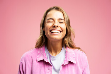 Closeup portrait of beautiful young woman with happy face, with white teeth isolated on pink...