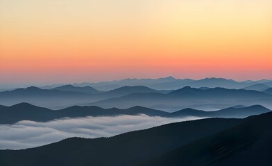 霧に覆われた山脈：オレンジと黄色のグラデーションが広がる空と、地平線上の薄いピンクの線、そして青と灰色の山々が霧やもやに覆われている、日の出または日没の風景 - obrazy, fototapety, plakaty