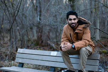 person sitting on a bench in the forest