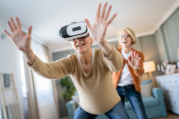 Women two senior females at home enjoy virtual reality VR headset