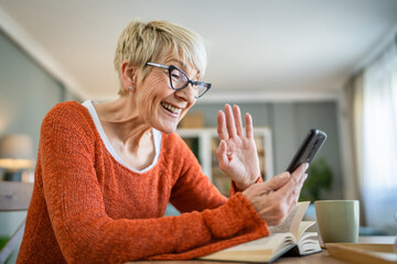 one mature senior caucasian woman use mobile phone smartphone at home