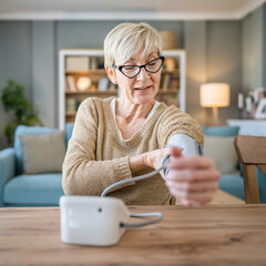 Senior caucasian woman check blood pressure measure device on hand