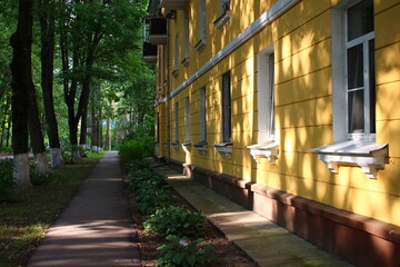 Fototapeta premium Shaded pedestrian path along the facade of a residential building