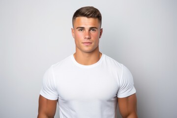 Handsome young man in white t-shirt on grey background