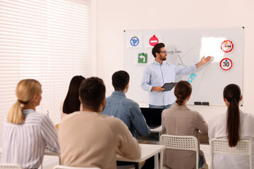 Teacher explaining traffic rules to audience during lesson in driving school