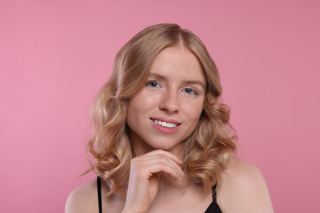 Obraz premium Portrait of beautiful woman with blonde hair on pink background