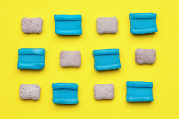 Different bubble gums on yellow background, flat lay