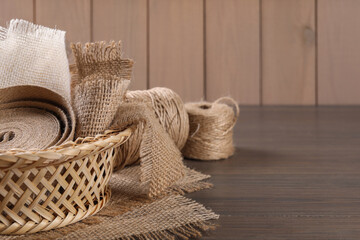 Pieces of burlap fabric and twine on table, closeup