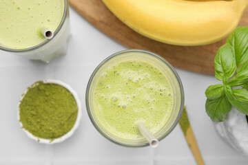 Glasses of tasty matcha smoothie on white table, flat lay
